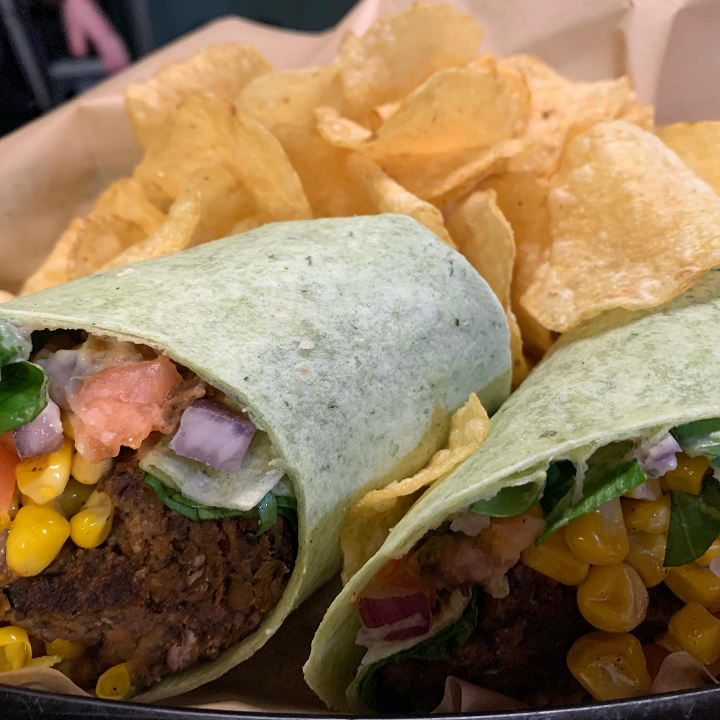Our house made black bean wrap, with lettuce, tomato, roasted corn, and avocado cucumber salasa in a spinach wrap